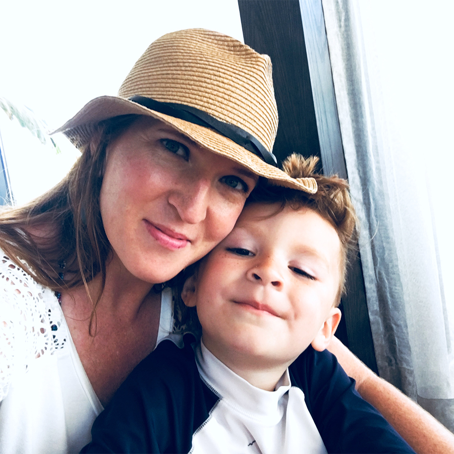 Mrs. Ayllon, Principal Teacher and founder of ABC Monsters, smiling with her son.
